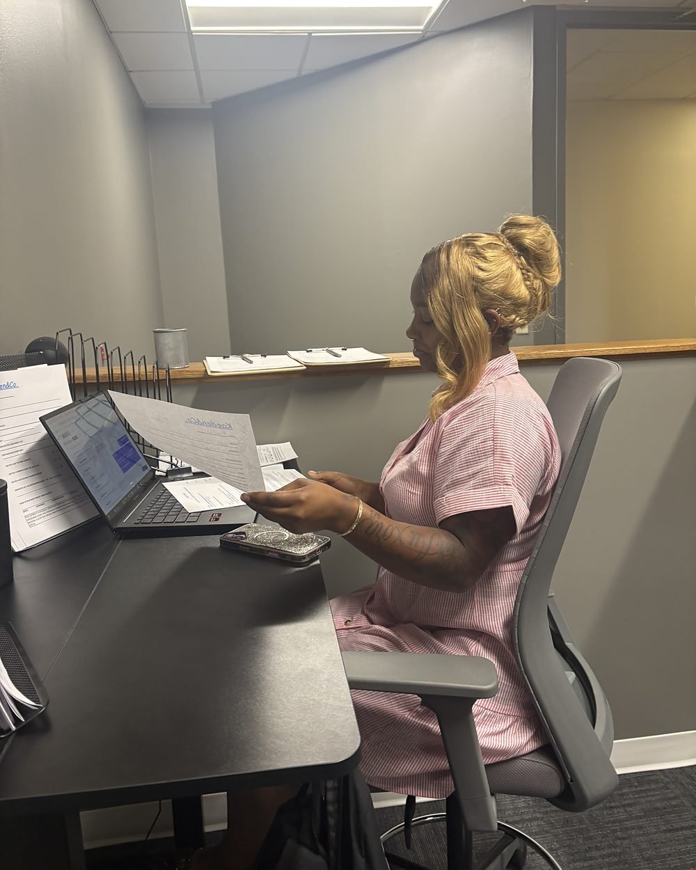A member of the Kaeden & Co. team reviewing paperwork at her desk